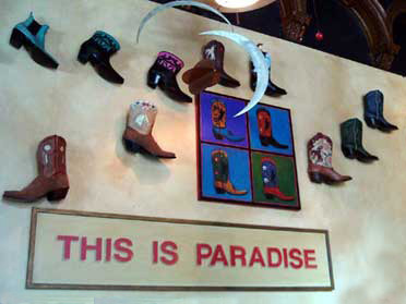 cowboy boots mounted on wall with art